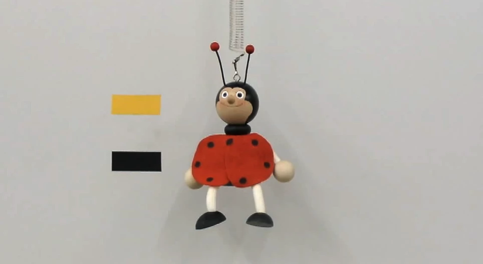 Rugón rezgő játékfigura rezgésidejének amplitúdófüggése