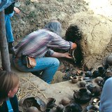Pottery, made with prehistoric techniques, is taken out of the oven