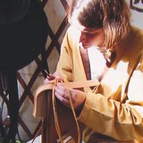 A traditional leather craftsman making a pouch
