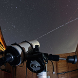 The International Space Station and Space Shuttle Discovery crossing in front of the telescope of an observatory