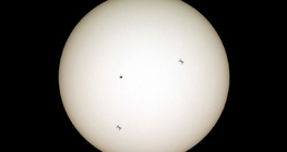 A Nemzetközi Űrállomás sziluettje (két különböző helyzetben) a napkorong előtt